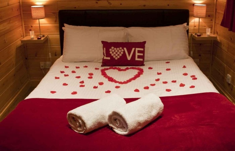 schlafzimmer romantisch deko-rote-bettdecke-rosenblatter