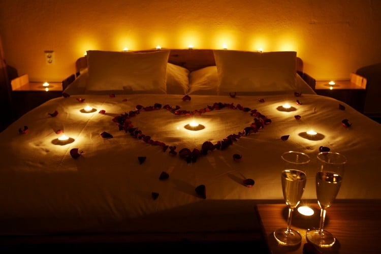 schlafzimmer-romantisch-teelichter-herz-rosenblaetter