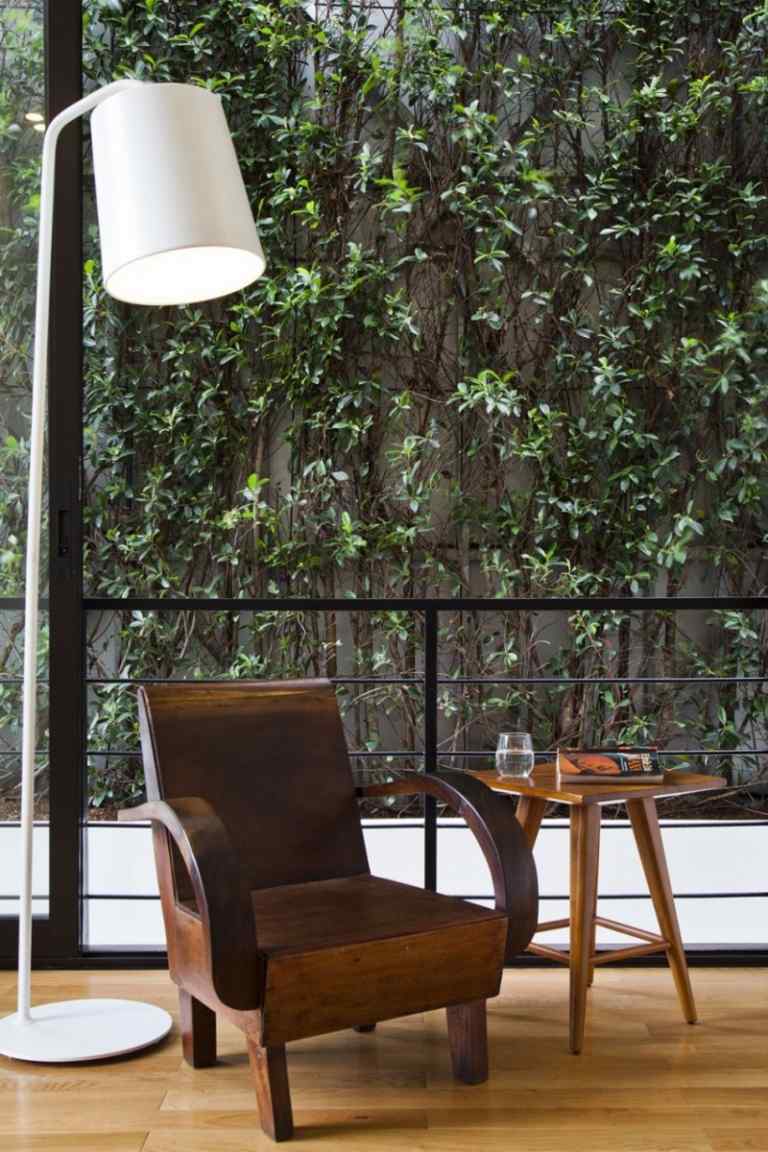 verikaler-Garten-ausblick-wohnzimmer-leselampe-sessel-beistelltisch-retro