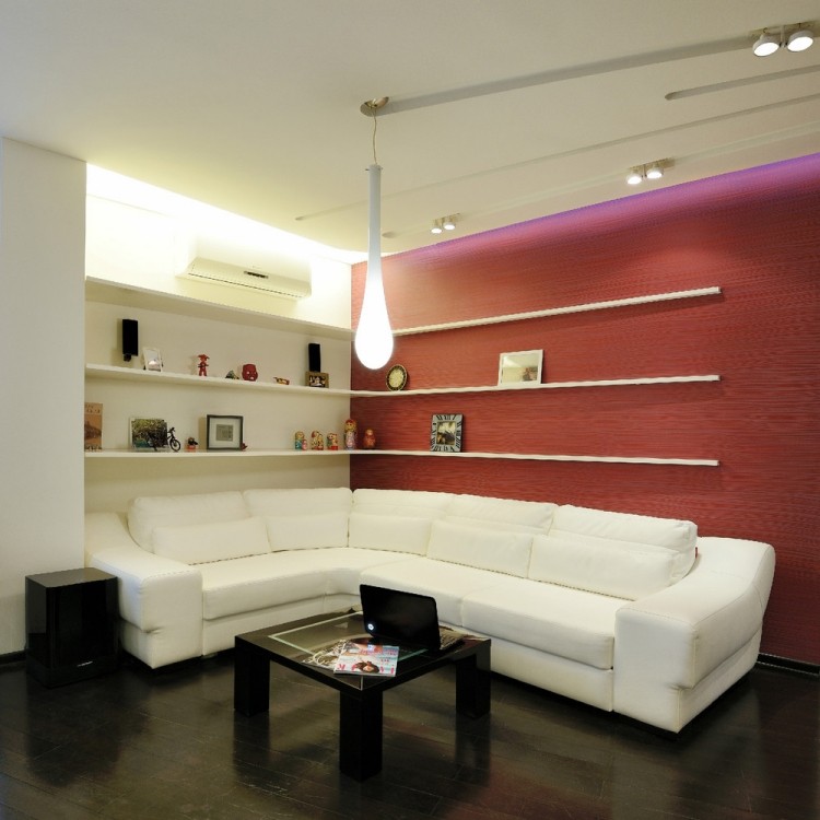 wohnzimmereinrichtung-ideen-modern-indirekte-led-deckenbeleuchtung-eckregale-weisses-sofa-rote-akzentwand