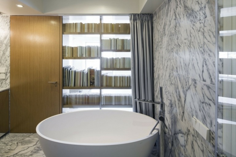 Einrichtung Dachgeschosswohnung Marmor Wandfliesen runde Badewanne Glaswand Holztür