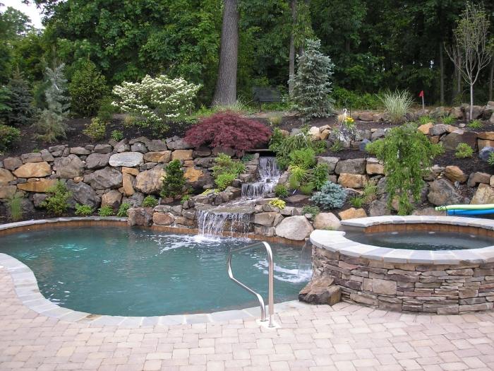 Gartengestaltung-mit-Steinen-Pool-oval-Whirlpool-Hang-Bepflanzung