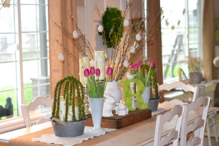 Osterdeko Tisch frische Blumen Weidenkätzchen Moos Hasenfiguren