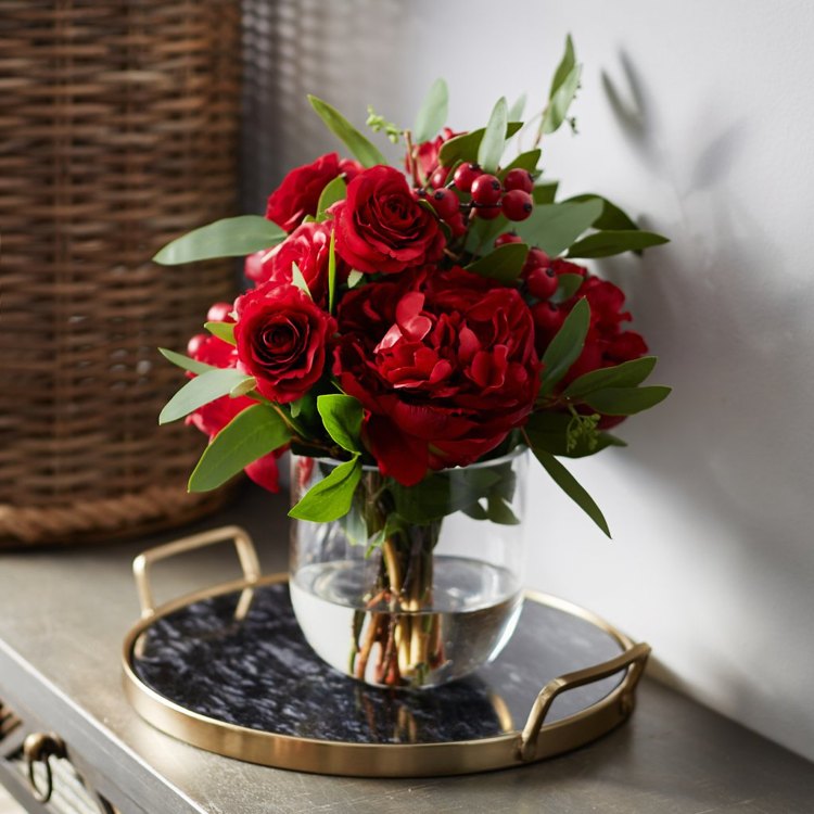 großes Glas dekorieren Rosen und Pfingstrosen und Beeren im roten Blumenstrauß kombinieren