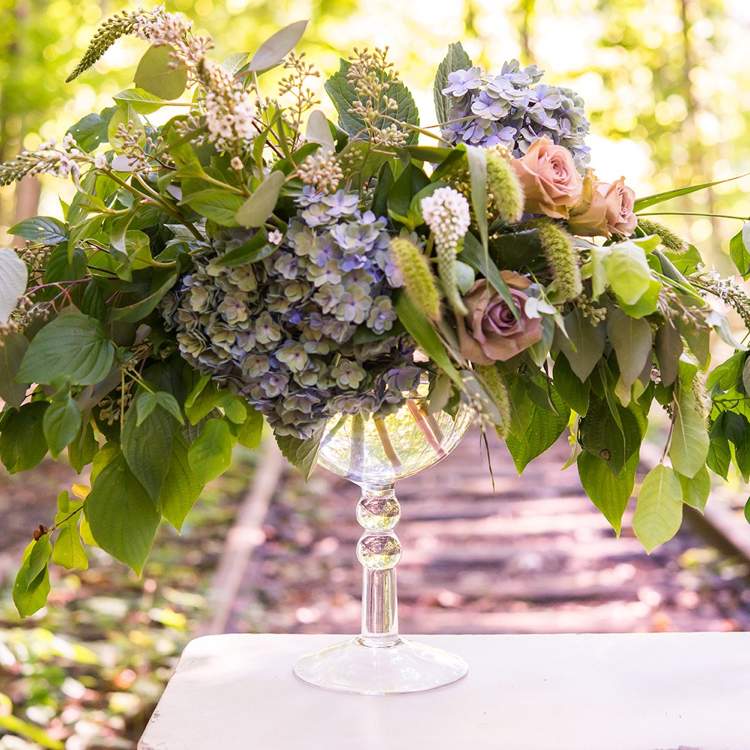 großes Glas dekorieren mit Frühlingsblumen Hortensien und Rosen und Weintraube