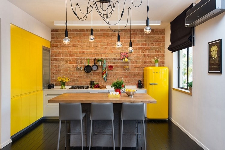Kleine Wohnung einrichten-kueche-backsteinwand-gelbe-akzente-kochinsel-schwarze-stuehle