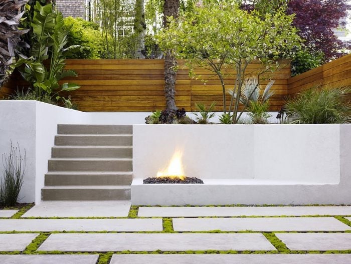 Moderne Gartengestaltung 2015 weiss-verputzte-stuetzmauer-offene-feuerstelle-holz-sichtschutzzaun