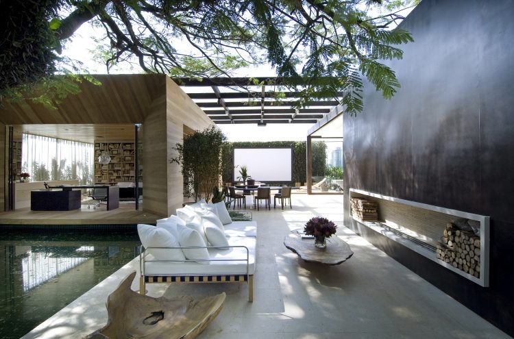 moderne-terrassengestaltung-mit-sofa-bed-outdoor-kamin-feuerholz-rustikale-akzente
