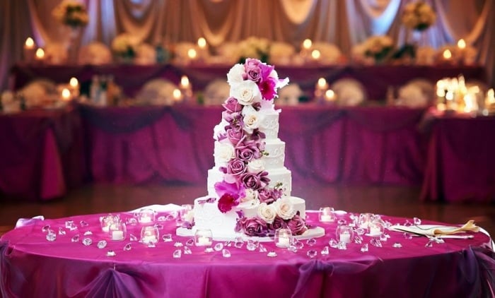 Purpur-Tisch-Dekoration-turmförmige-Hochzeitstorte-weiße-Creme