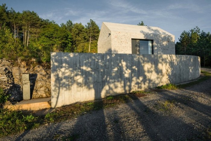 haus design in slowenien grundstück beton mauer stein wald