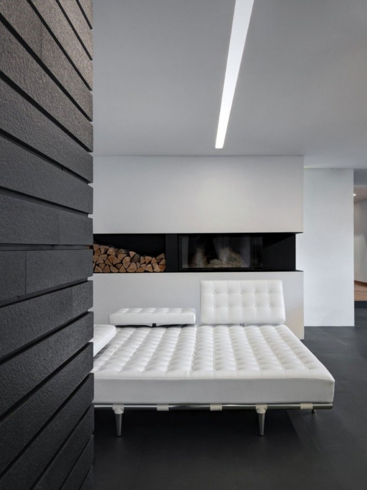 wohnzimmer-mit-kamin-brennholz-minimalistisch-leder-bett