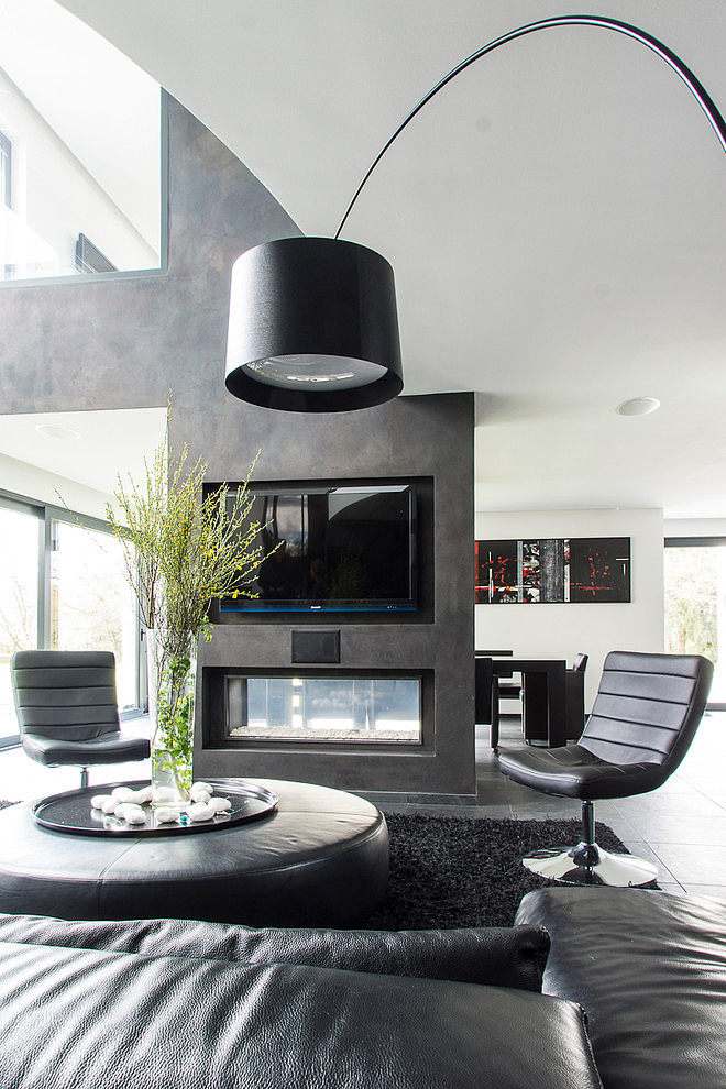 Wohnräume mit Kamin ofen-glas-zwei-seiten-raumteiler-schwarze-ledermoebel