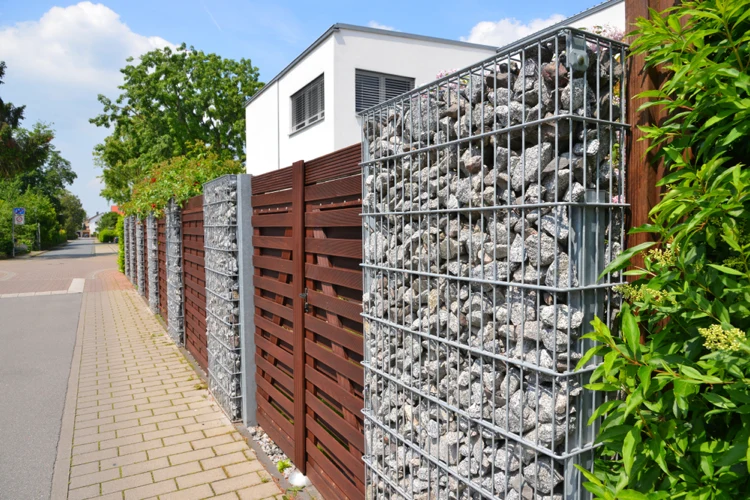 materialkombination für den gartenzaun gabionen mit steinen gefüllt und elemente aus holzbrettern