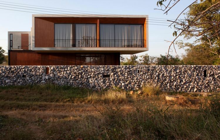minimalistisches-Haus-mit-Zaun-aus-Stein