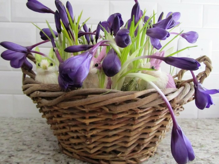 oster tischdeko aus frühlingsblumen krokusse lila blau korb hasen