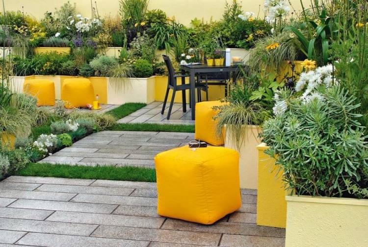 terrasse-einrichten-gestaltung-gelb-aussen-pflanzen-poufs-fliesen-blumekuebel-gruen-garten