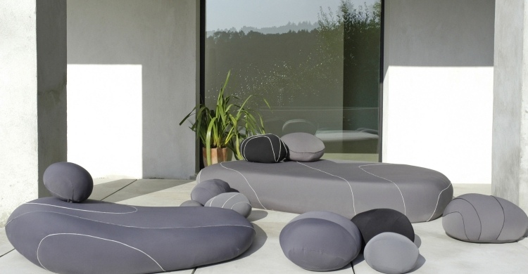 terrasse-einrichten-gestaltung-livingstone-aussen-polster-grau-steine-liegen-poufs-hocker-elemente-modern-design-lounge