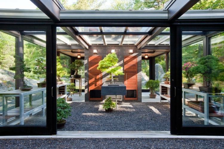 design wintergarten teestube kieselsteine fussbodenbelag bonsai pflanze dach glas