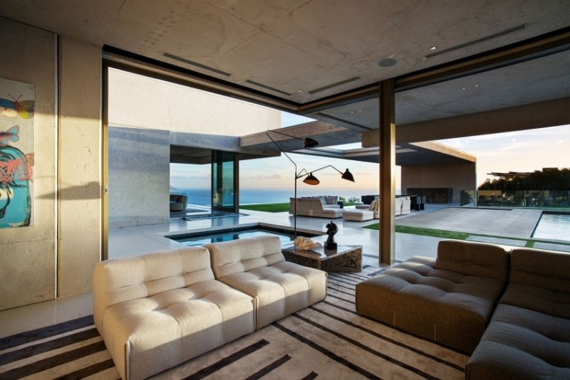 einrichtung-wohnzimmer-couches-module-teppich-beige-schwarz-garten-fensterwand