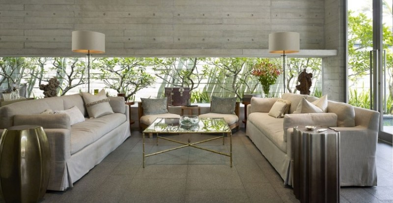 einrichtung-wohnzimmer-grau-beton-couches-geneueber-stehlampen-fensterwand-garten