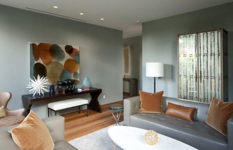 einrichtung-wohnzimmer-ledercouches-grau-kissen-beige-sideboard-wandfarbe-grau-bild