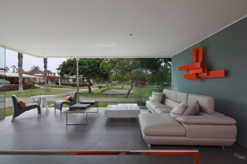 einrichtung-wohnzimmer-modern-ledercouch-grau-orange-wand-couchtisch-hochglanz-fensterwand
