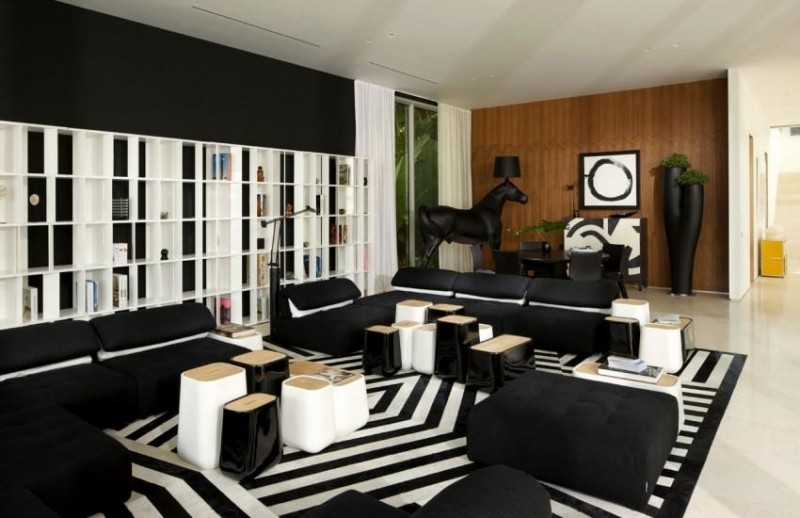 einrichtung-wohnzimmer-schwarz-weiss-streifen-teppich-hocker-couch-module-skulptur-pferd-wandregal