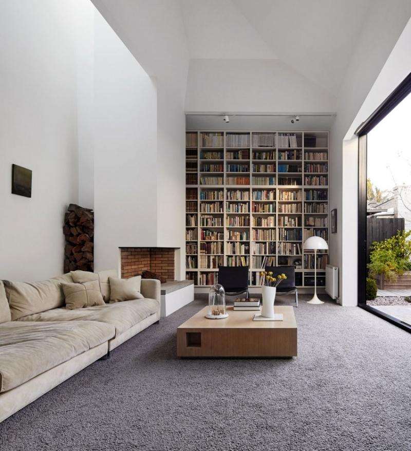 Einrichtung fürs Wohnzimmer -teppichboden-grau-couch-beige-velour-couchtisch-holz-bibliothek-terrassenfenster-kaminoffen-weiss