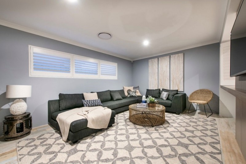 Einrichtung fürs Wohnzimmer -wandfarbe-grau-sofa-dunkelgrau-teppich-muster-grauweiss-couchtisch-stuhl-geflecht