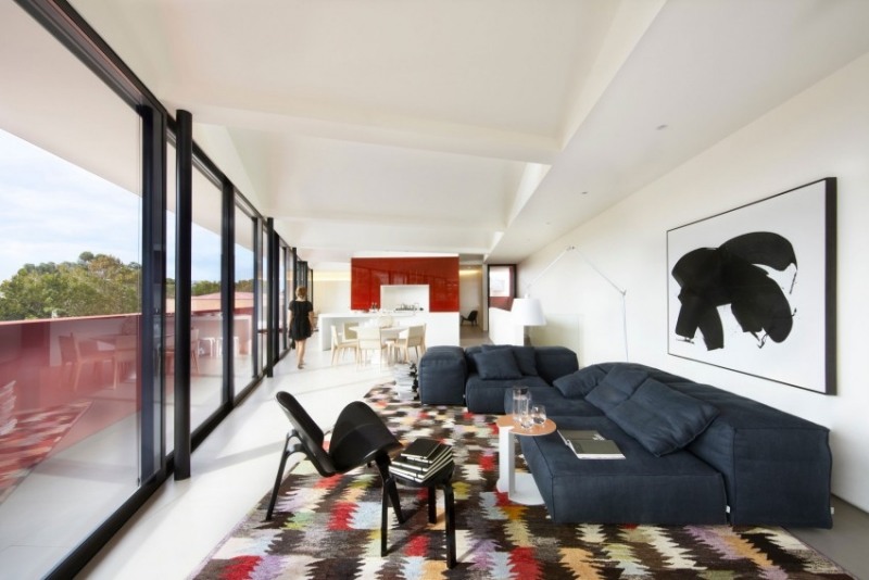 Einrichtung fürs Wohnzimmer -weiss-couch-dunkelblau-teppich-bunt-fensterwand