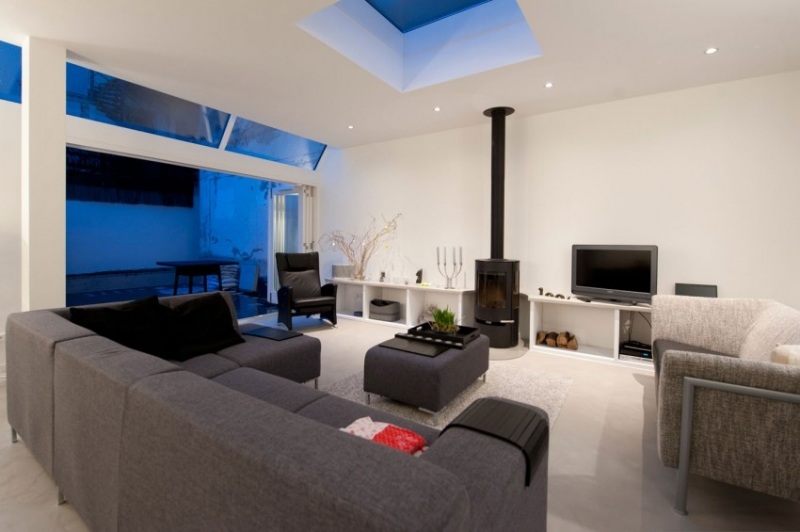 Einrichtung fürs Wohnzimmer -weiss-sofas-grau-kaminofen-schwarz-dachfenster-gartenfenster