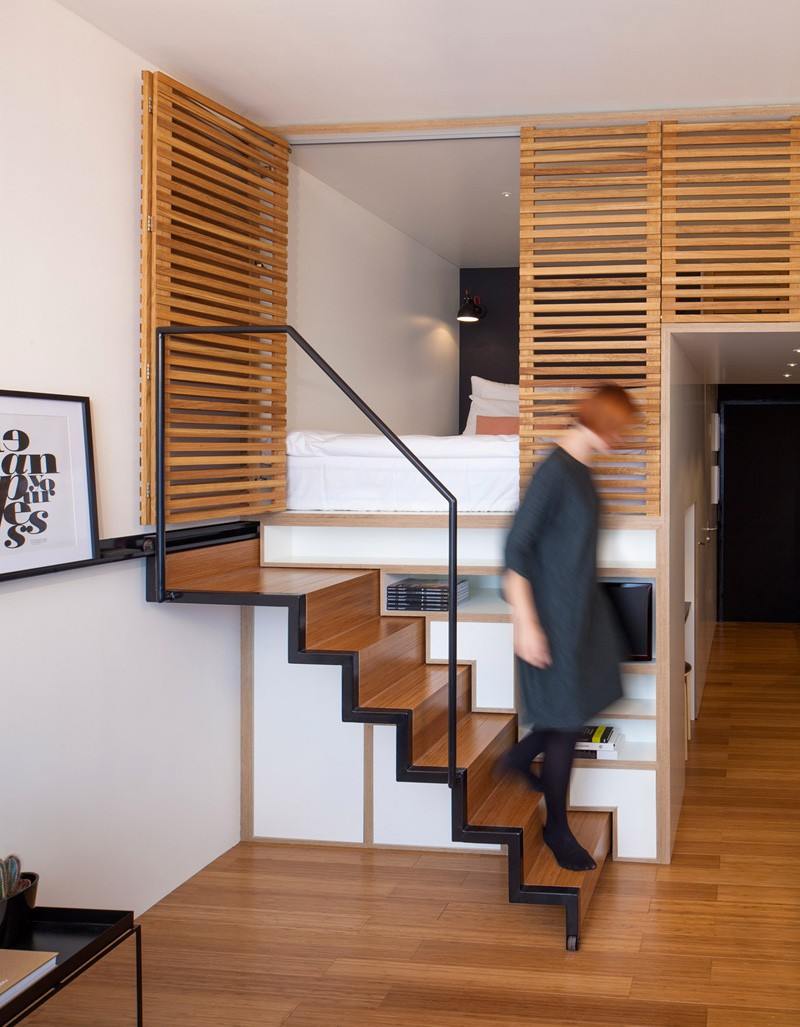 Einzimmerwohnung gestalten -funktionalitaet-treppeversteckt-ausziehbar-holz-minimalistisch-schlafbereich-weiss-schwarz
