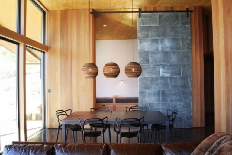 esszimmer-einrichtung-esstisch-stuehle-schwarz-holz-waende-terrassenfenster-granit-wand-leder-couch