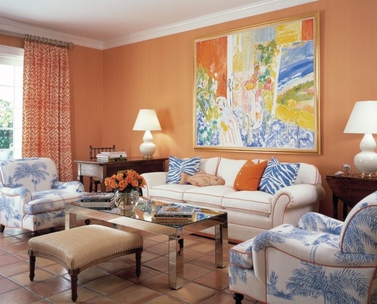 Nach Feng Shui Wohnzimmer einrichten -orange-bild-couch-sessel-weiss-muster-kissen-terrakotta-fliesen-boden