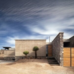 haus aus recycelten materialien flussstein wueste palmen treppe