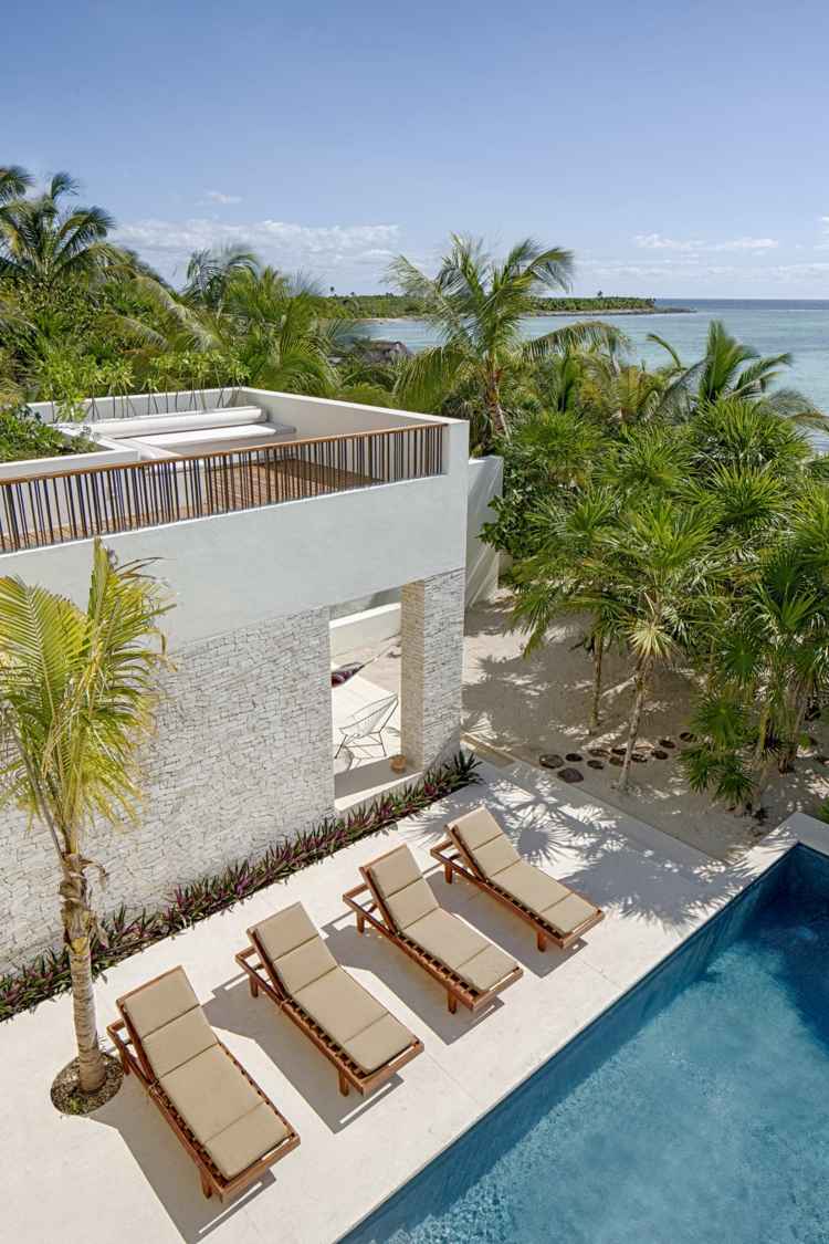 haus mit rustikalem flair poolbereich liegestuehle palme terrasse