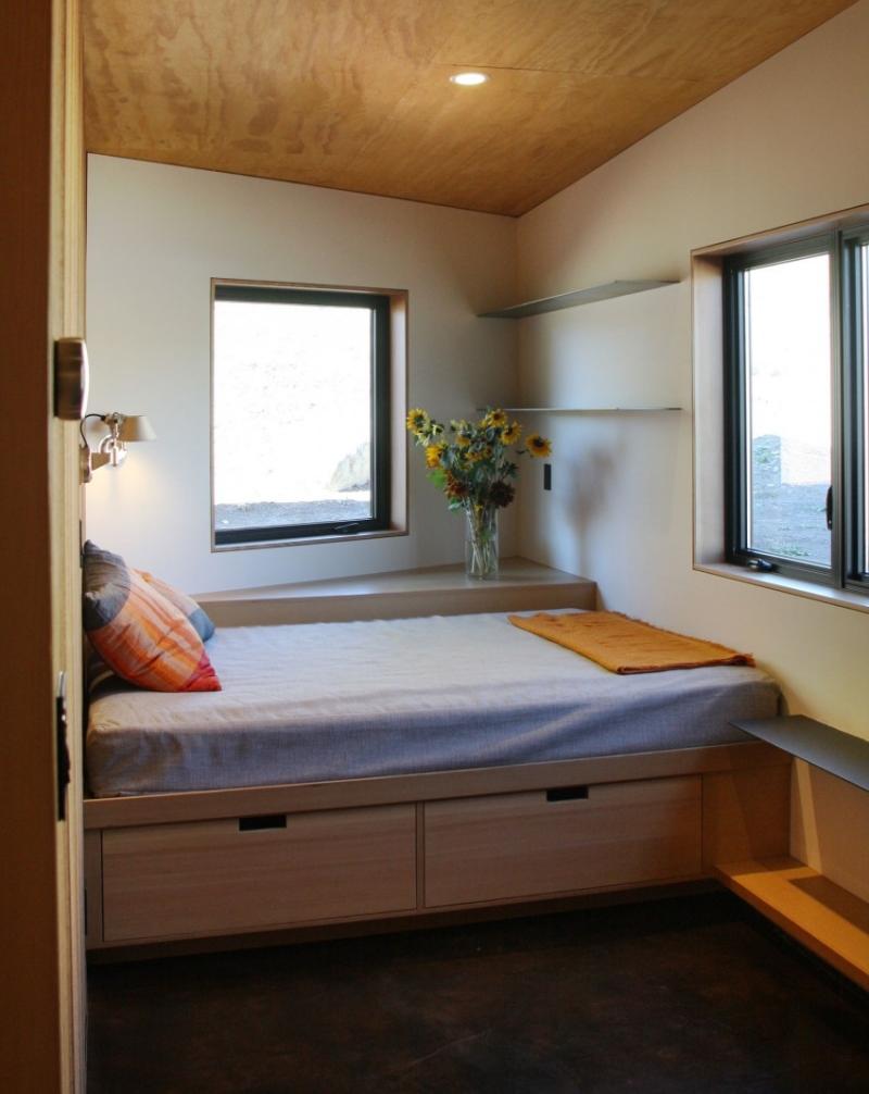 kleines-schlafzimmer-holz-decke-bett-bettkasten-wandregale