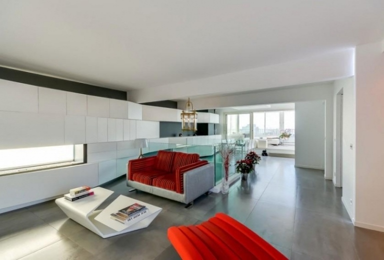 Moderne Inneneinrichtung -interieur-rot-polster-couch-bodenbelag-grau-weiss-wand-couchtisch-geometrisch