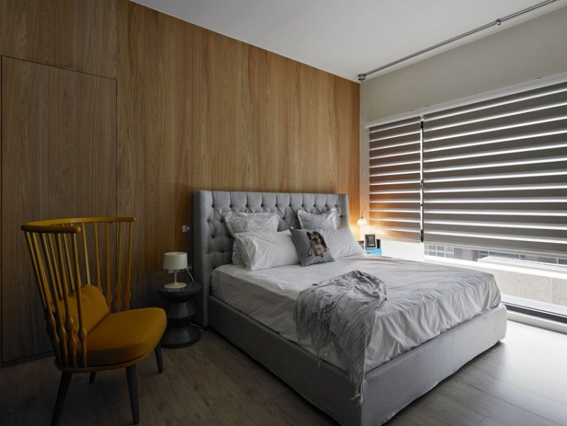 moderne-schlafzimmer-holz-wandverkleidung-graues-polsterbett-gesteppter-kopfteil