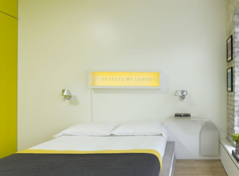 moderne-schlafzimmer-wanddeko-beleuchtet-designer-nachttisch-gelbe-akzente