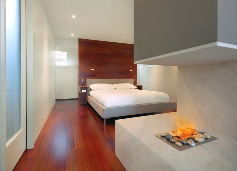 modernes-schlafzimmer-holzboden-wand-rotton-marmor-offene-feuerstelle