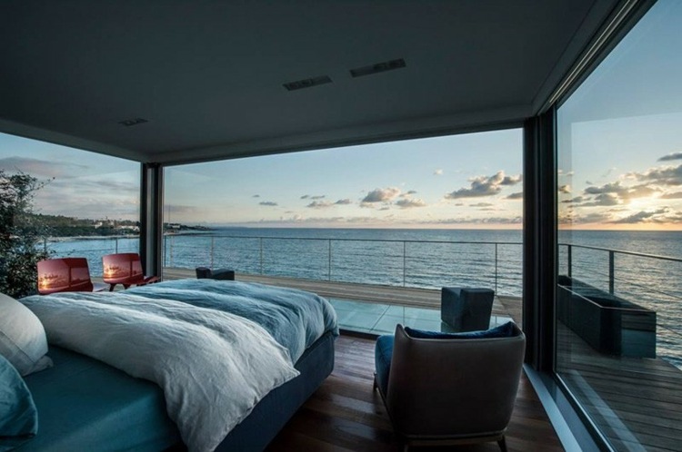 stil mediterran strandhaus schlafzimmer bett hellblau sessel parkett stuhl rot