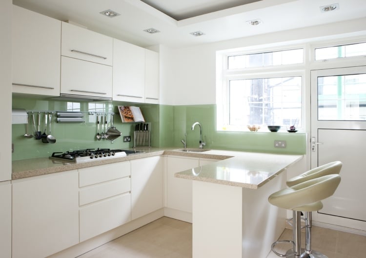 Küche Wandgestaltung l-form-halbinsel-weisse-schranke-salbeigruener-glas-spritzschutz