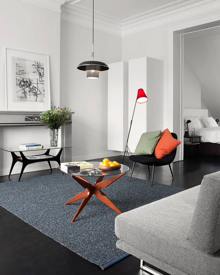 einrichtungsideen-wohnzimmer-grau-teppichcouch-polsterstuhl-leselampe-orange-couchtisch-glasplatte-wandfarbe-weiss-bild-haengeleuchte