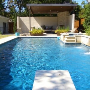 garten mit pool sprungbrett sitzbereich kamin ueberdachung wasserfall