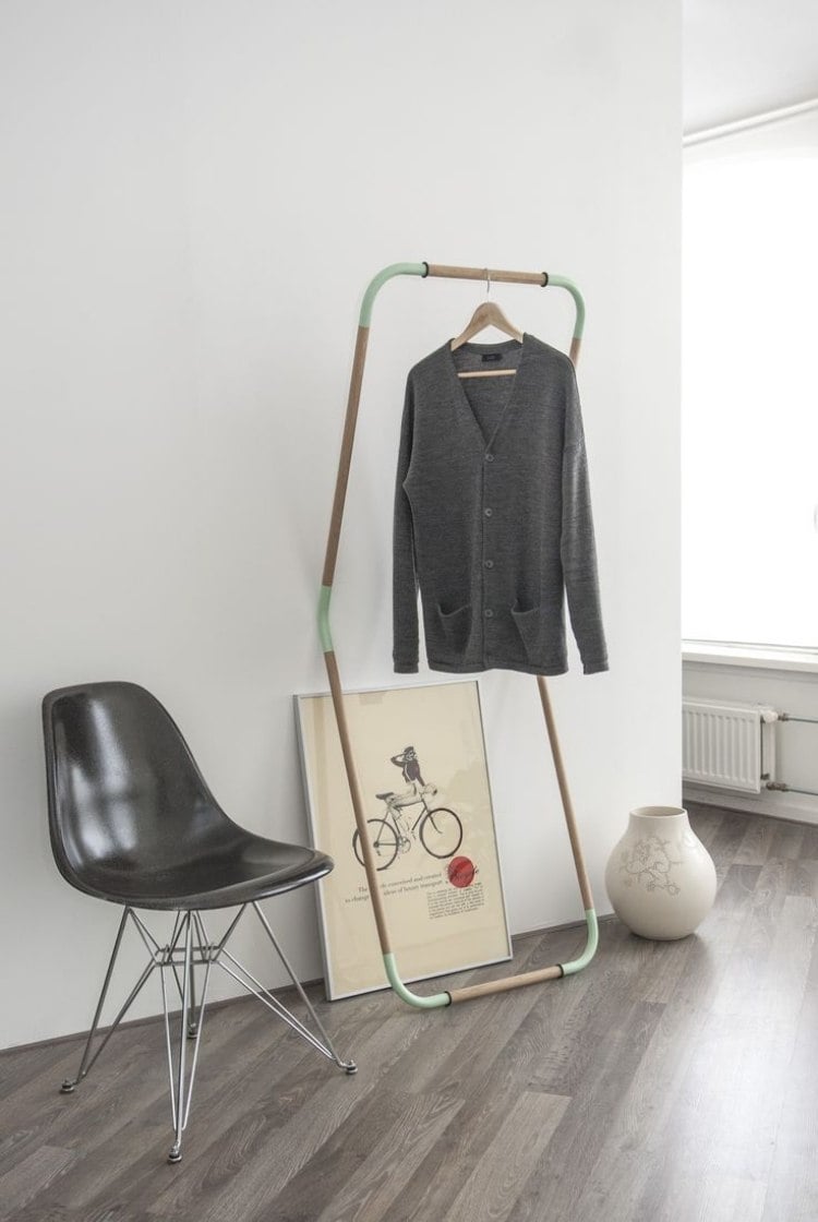 kleiderstange-kleiderschrank-kreativ-design-geknackt-schwarz-laminatboden-grau-waende-weiss