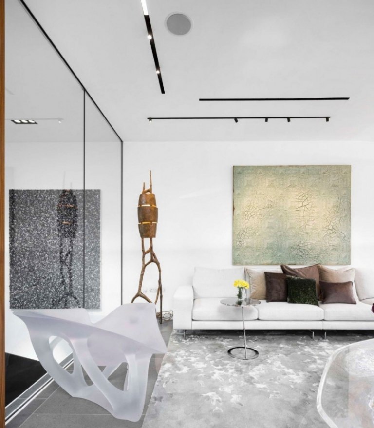Moderne Einrichtung -couch-weiss-bild-skulptur-plastik-durchsichtig-nebentisch-teppich-grau