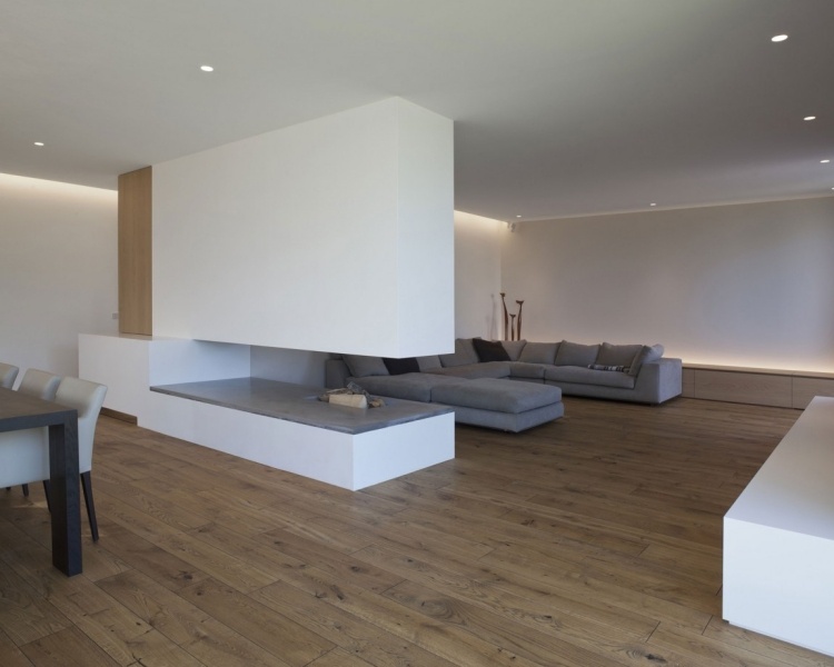 offener-kamin-holzboden-sofa-gross-eckig-weiss-minimalistisch-offen-indirekte-beleuchtung
