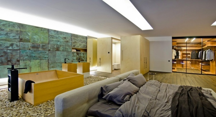 Schlafzimmer mit Whirlpool -modern-wanne-holz-grau-bettwaesche-kieselsteine-offen