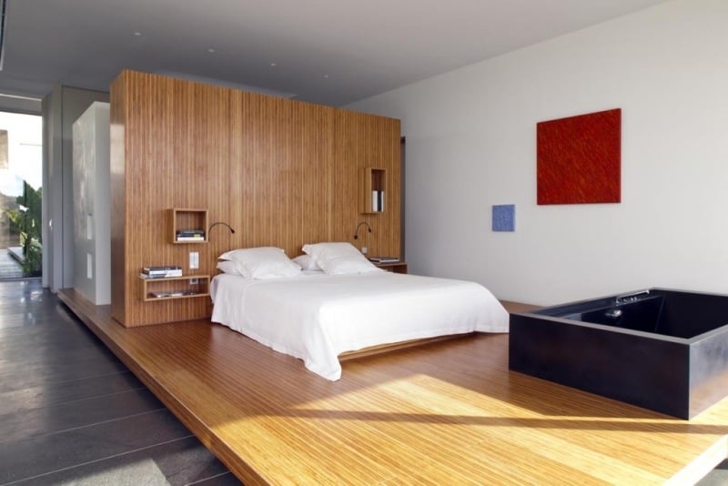 Schlafzimmer mit Whirlpool -offen-raeume-wanne-schwarz-bett-holz-verkleidung-wand-boden-fundament